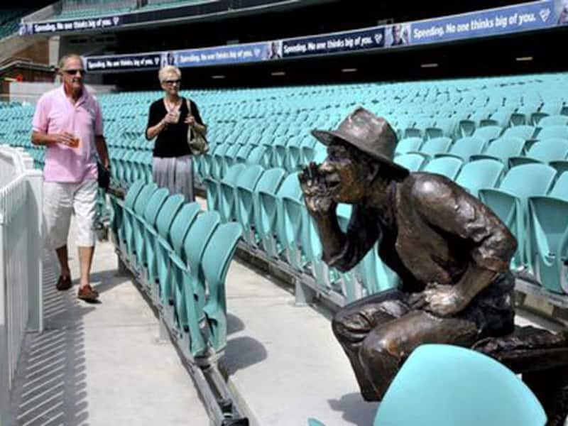 The seated spectator, cast in bronze, hand beside his open mouth, poised to throw his voice into the action in the middle, is a throwback into the past of the immortal barracker Yabba. The barracker who was active in &acirc;The Hill&acirc; during the early days of the century to become one of the rare spectators to find his own likeness seated in the stands forever