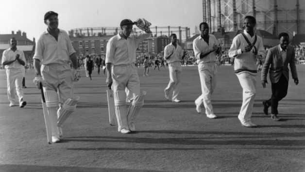 English batsmen Tom Graveney (left) and John Murray leave the pitch at The Oval, after a record unbroken 8th wicket partnership of 164 runs in a Test match against the West Indies. The Englishmen are applauded by the West Indies players, led by captain Gary Sobers (right) and Wes Hall (behind Sobers) © Getty Images
