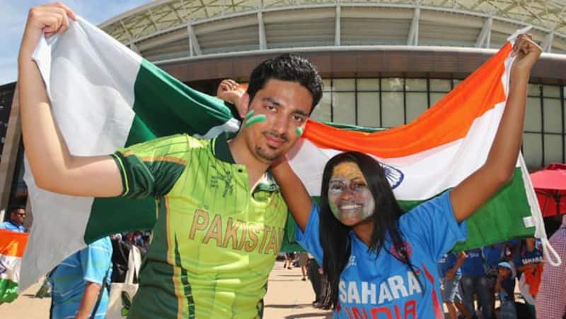 A Pakistan and an Indian supporter (right) pose with their respective flags © Getty Images
