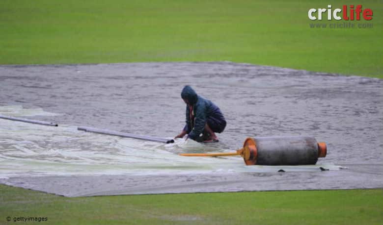 A groundsman works in the field during rain at the Sher-e Bangla National Stadium