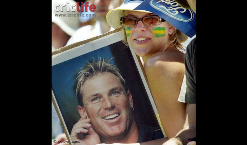 An Australian fan holds a poster of Shane Warne who was serving a ban for drug taking