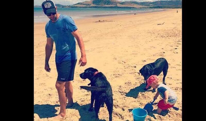 Ben Hilfenhaus playing with his dogs and son.