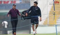 Virat Kohli greets a pitch curator by touching his feet