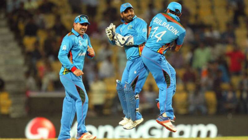 Mohammad Shahzad (centre) and Gulbadin Naib (right) celebrate after Afghanistan win over Zimbabwe, while Samiullah Shenwari looks on. Image courtesy: AFP