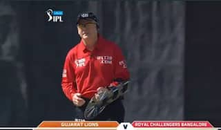 Umpire Bruce Oxenford takes field with an armguard to protect himself from brutal RCB batting