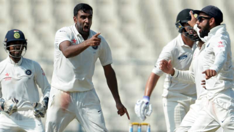 Ravichandran Ashwin(C) and Virat Kohli celebrate with teammates after the wicket of Ross Taylor during the 4th day of the 2nd Test between India and New Zealand
