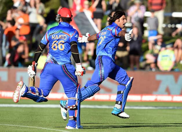 Shapoor Zadran went crazy after hitting the winning boundary, while Hamid Hassan tries to catch him © AFP