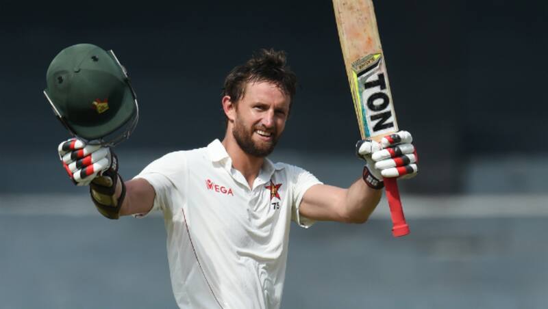Craig Ervine raises his bat after his century © AFP