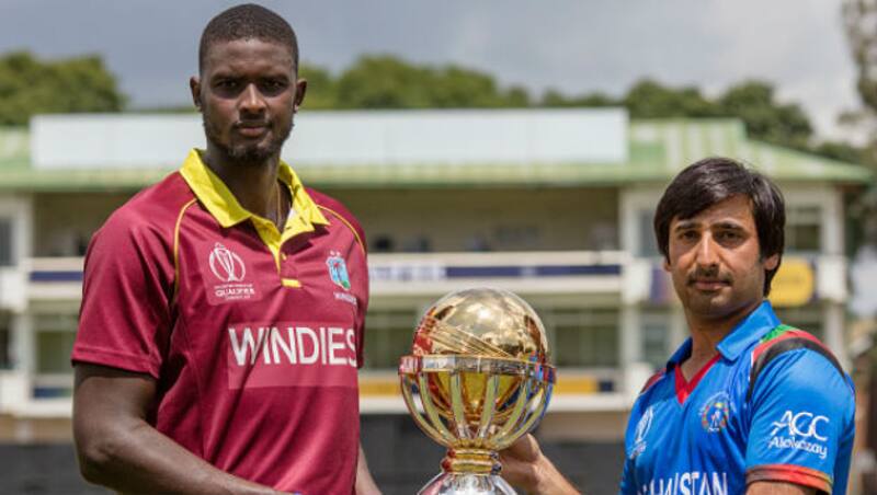 Jason Holder (L) and Asghar Stanikzai pose with the trophy &Acirc;&copy; Getty Images
