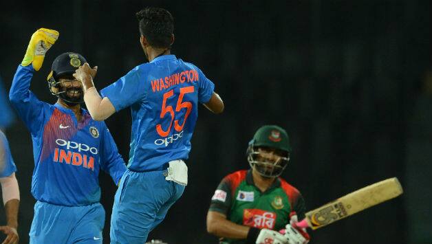 Washington Sundar celebrates with Dinesh Karthik after he dismissed Tamim Iqbal © AFP