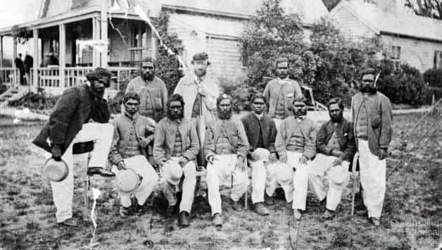 A group of Australian Aboriginal cricketers at MCG (some records claim it was taken at Albert Club, Redfern). Photo courtesy: Wikimedia Commons. Back: Tarpot, Tom Wills, Johnny Mullagh. Front: King Cole (leg on chair), Jellico, Peter, Red Cap, Harry Rose, Bullocky, Johnny Cuzens, Dick-a-Dick (standing).