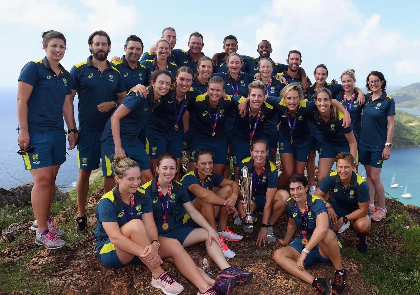 The Australia playing and coaching staff pose for a photo with the trophy in Antigua.