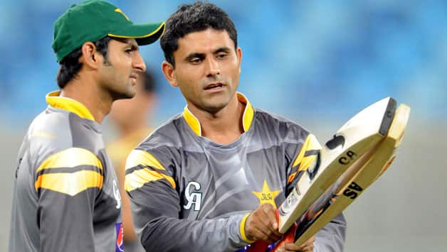 Pakistani cricketer Abdul Razzaq (R) and Shoaib Malik check bats during a training session