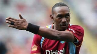Players stand by Dwayne Bravo during toss